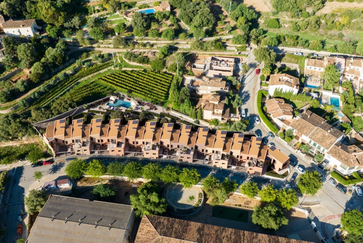 Widok z lotu ptaka na inwestycję ES Voltor w Esporles na Majorce; domy szeregowe Taylor Wimpey przy winnicach.
