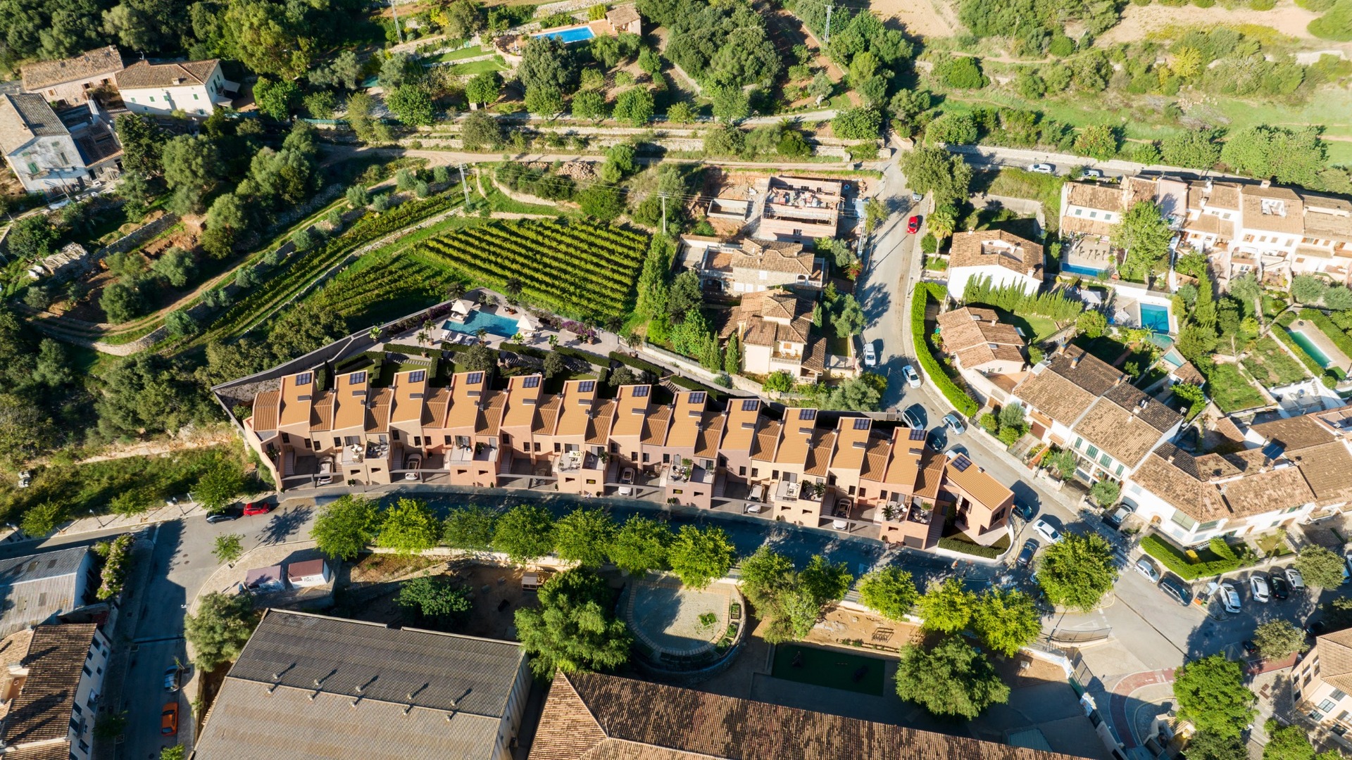 Widok z lotu ptaka na inwestycję ES Voltor w Esporles na Majorce; domy szeregowe Taylor Wimpey przy winnicach.