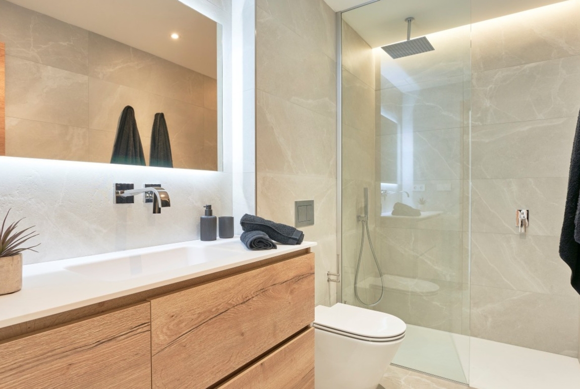 Nowoczesna łazienka z prysznicem walk‑in, jasnymi płytkami i dużym lustrem w ES Voltor w Esporles.