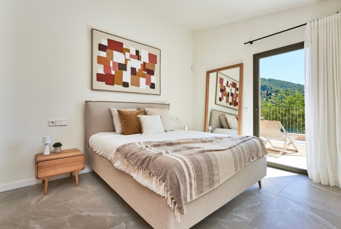 Sypialnia z łóżkiem małżeńskim, obrazem i wyjściem na taras z widokiem na zieleń – ES Voltor, Esporles.