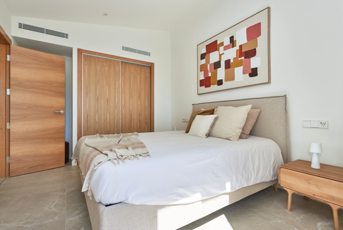Jasna sypialnia z łóżkiem, szafą przesuwną i drzwiami z naturalnego drewna – ES Voltor w Esporles.