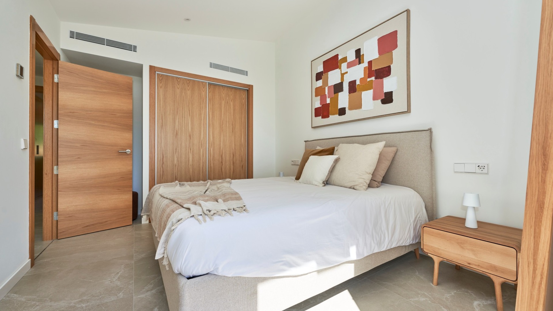 Jasna sypialnia z łóżkiem, szafą przesuwną i drzwiami z naturalnego drewna – ES Voltor w Esporles.