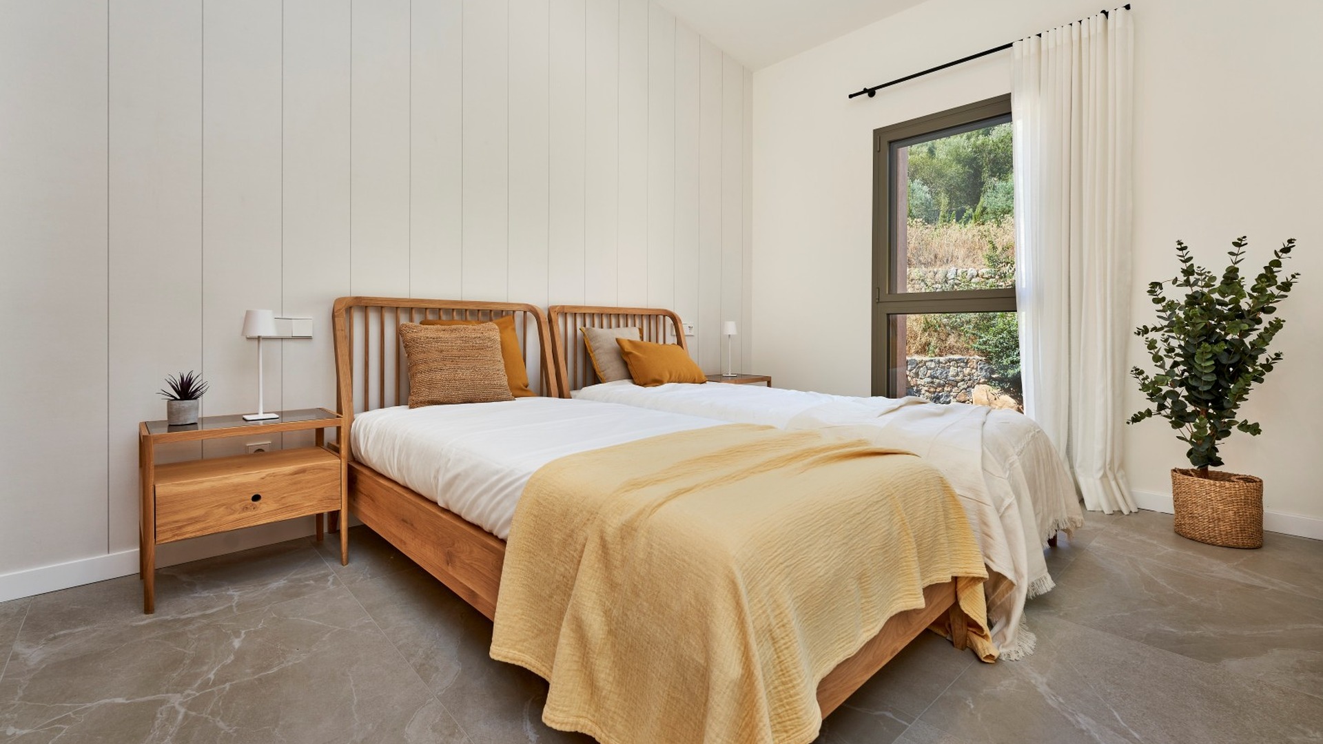 Pokój gościnny z dwoma łóżkami, drewnianymi meblami i oknem – inwestycja ES Voltor w Esporles.