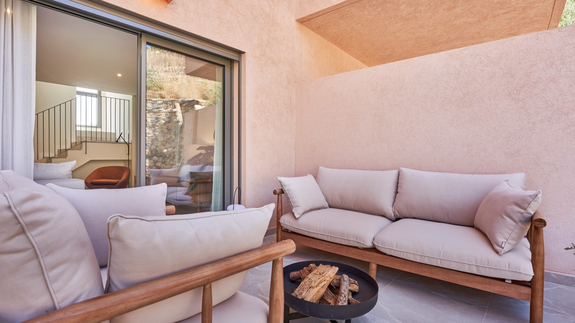 Zbliżenie na patio z sofami ogrodowymi i kominkiem ogrodowym – inwestycja ES Voltor, Esporles.