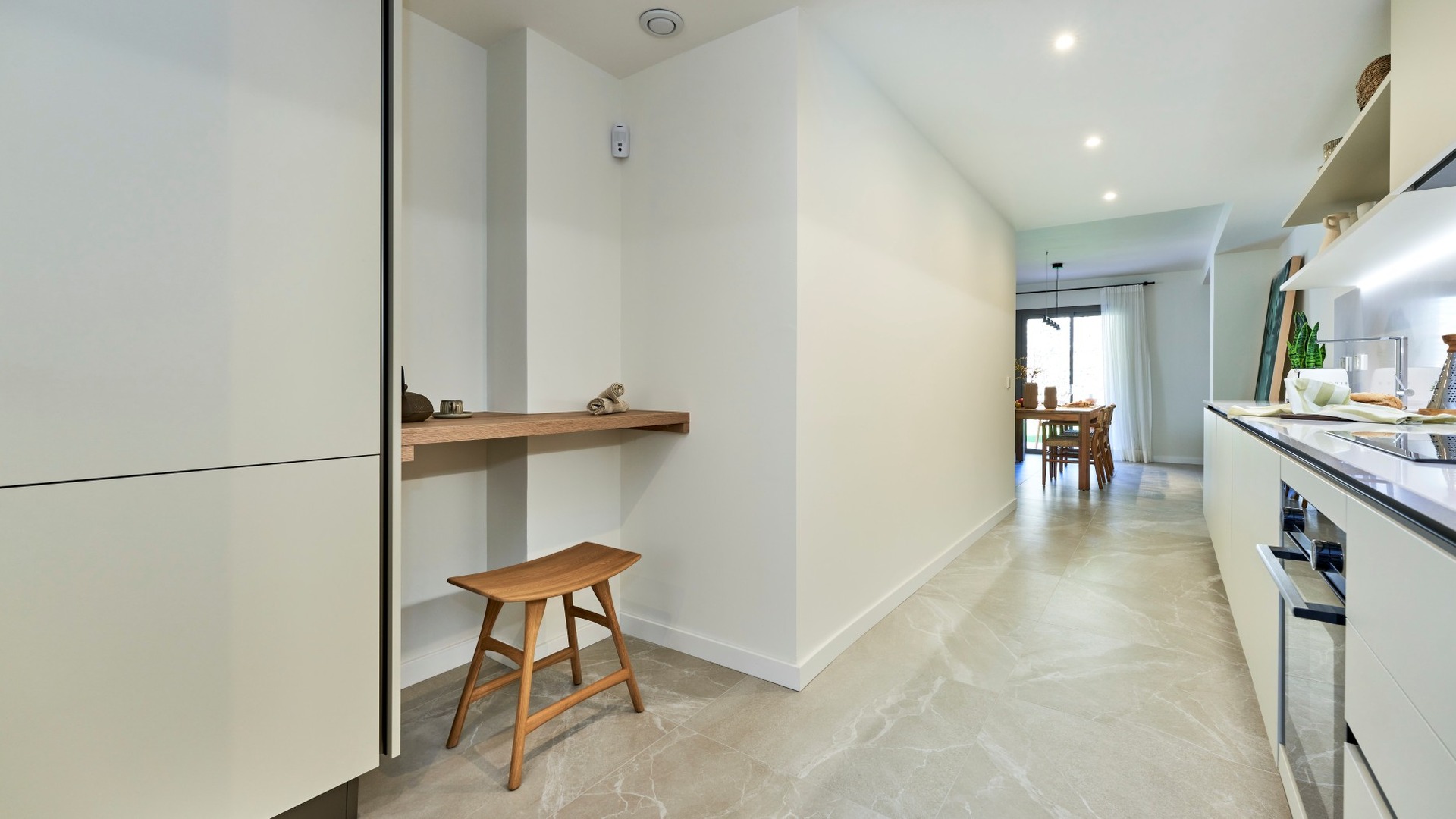 Widok z kuchni na jadalnię; długi korytarz, zabudowa kuchenna i naturalne światło – ES Voltor, Esporles.