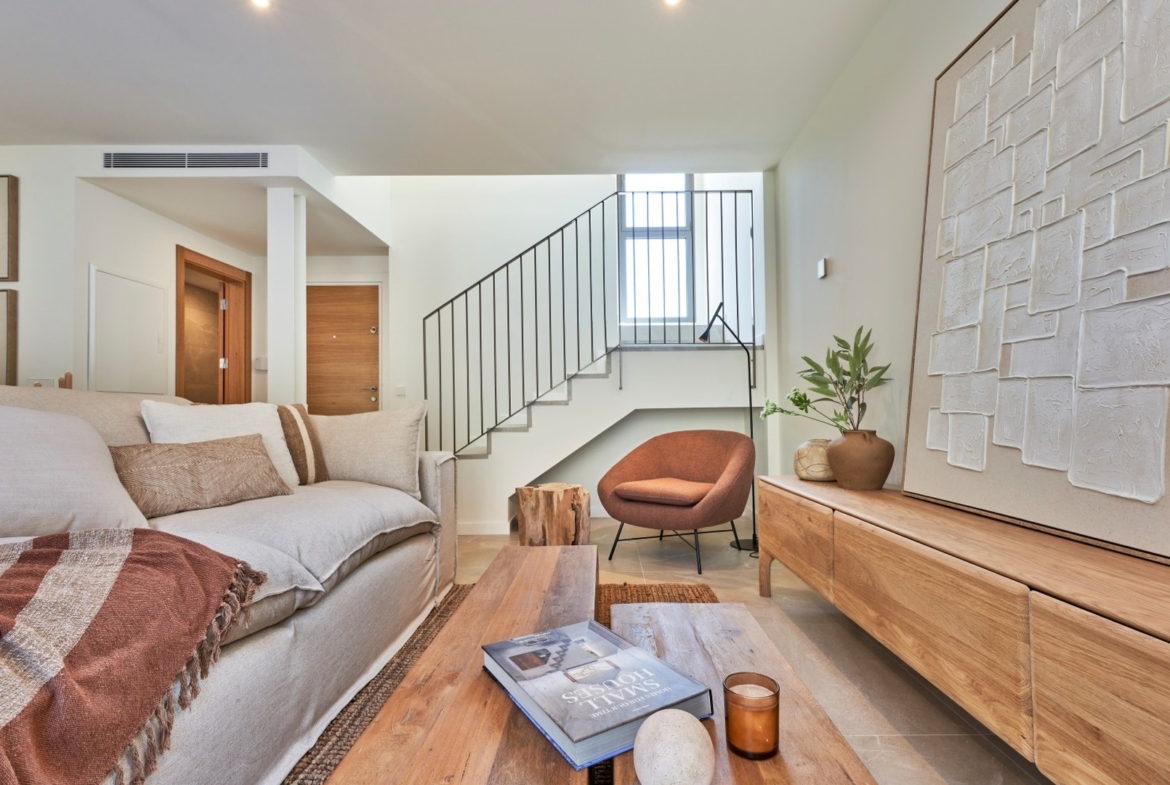 Salon z fotelem, lampą stojącą i schodami; nowoczesna aranżacja w ES Voltor, Esporles.