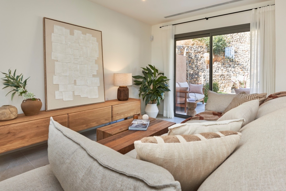 Jadalnia z dużym stołem i krzesłami z plecionką obok salonu – inwestycja ES Voltor w Esporles.