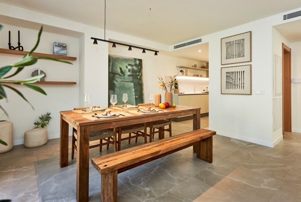 Duży drewniany stół, krzesła z plecionką oraz widok na kuchnię i salon – ES Voltor, Esporles.