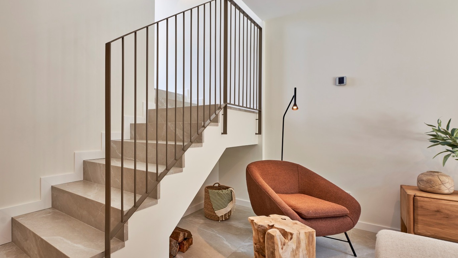 Salon z wygodnym fotelem i schodami wykończonymi kamieniem w inwestycji ES Voltor, Esporles.