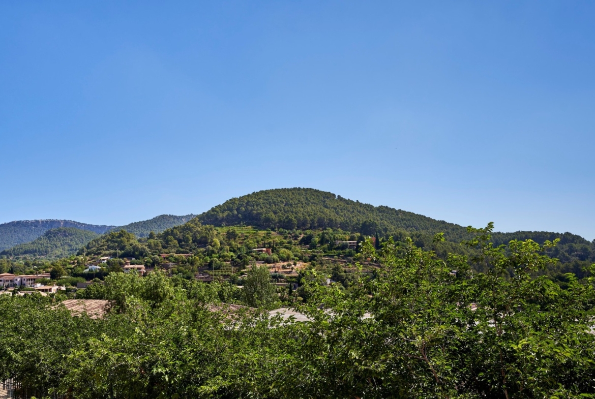 Panoramiczny widok na Esporles i zielone wzgórza Serra de Tramuntana na Majorce.
