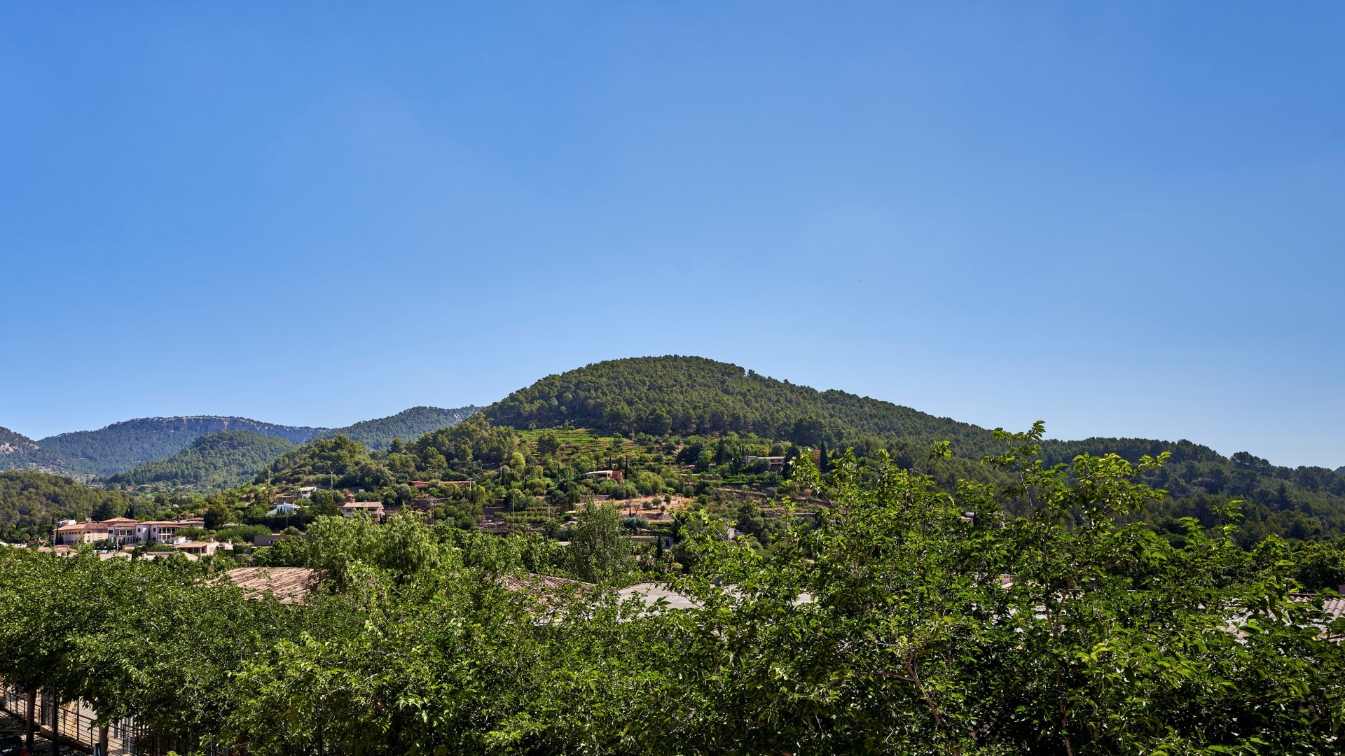 Panoramiczny widok na Esporles i zielone wzgórza Serra de Tramuntana na Majorce.