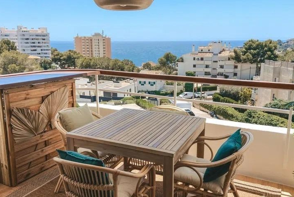 Stylowy balkon z rattanowymi meblami i panoramicznym widokiem na Morze Śródziemne w dzielnicy Sant Agustí, Palma de Mallorca.