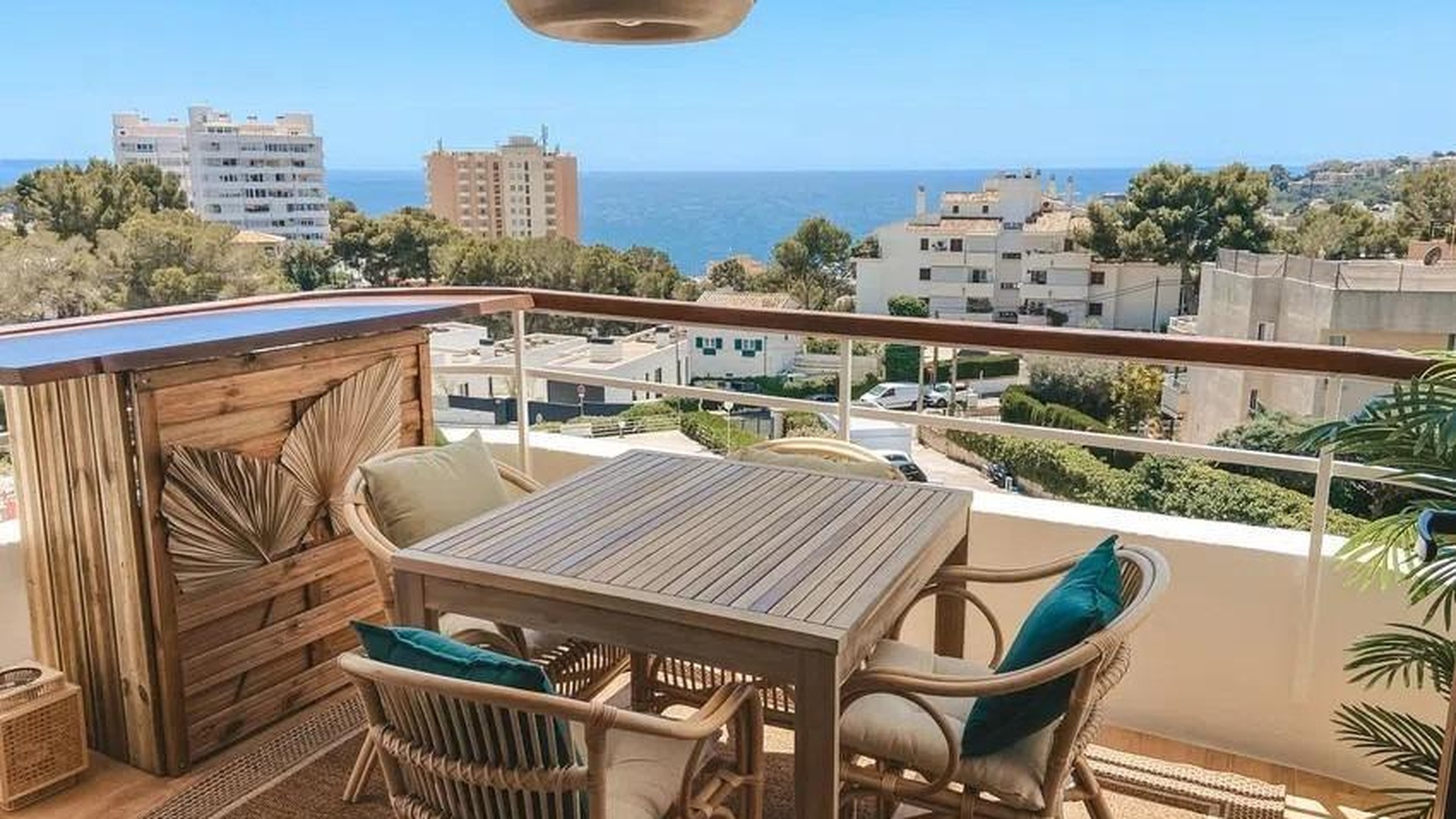 Stylowy balkon z rattanowymi meblami i panoramicznym widokiem na Morze Śródziemne w dzielnicy Sant Agustí, Palma de Mallorca.