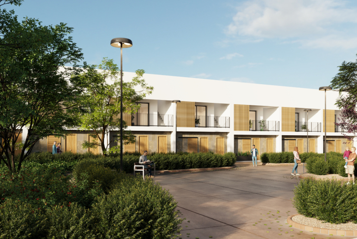 Zadbany dziedziniec z alejkami, ławkami i nasadzeniami.