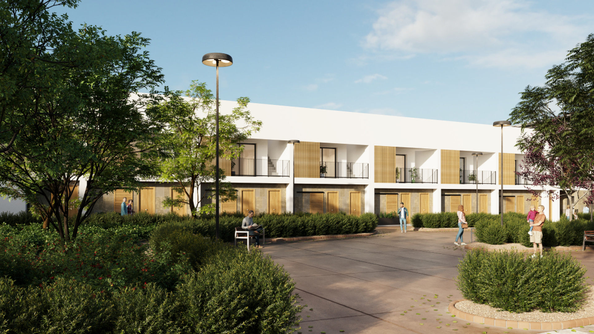 Zadbany dziedziniec z alejkami, ławkami i nasadzeniami.