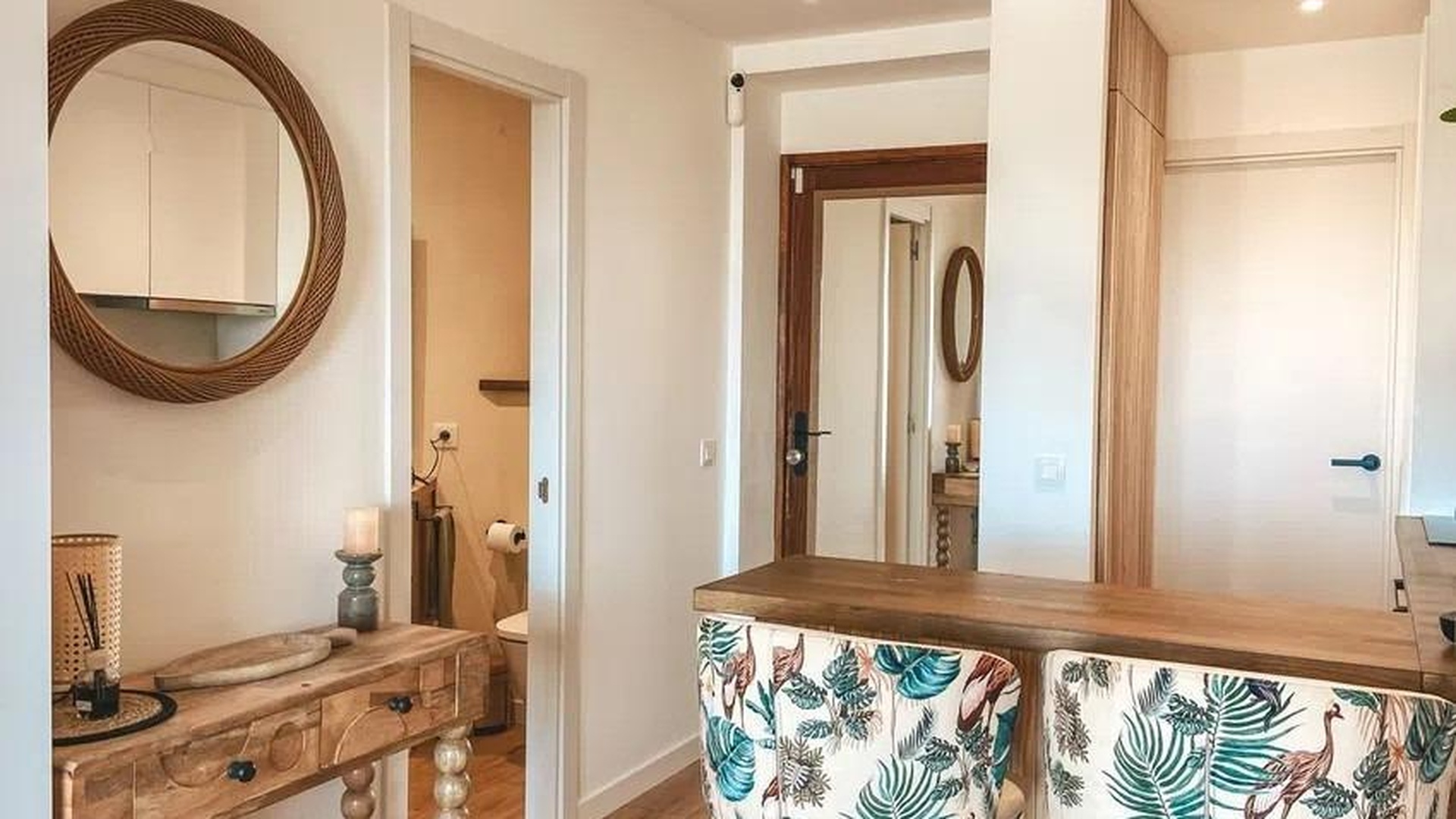 Widok na korytarz i wyspę barową z tapicerowanymi hokerami w apartamencie w Sant Agustí.