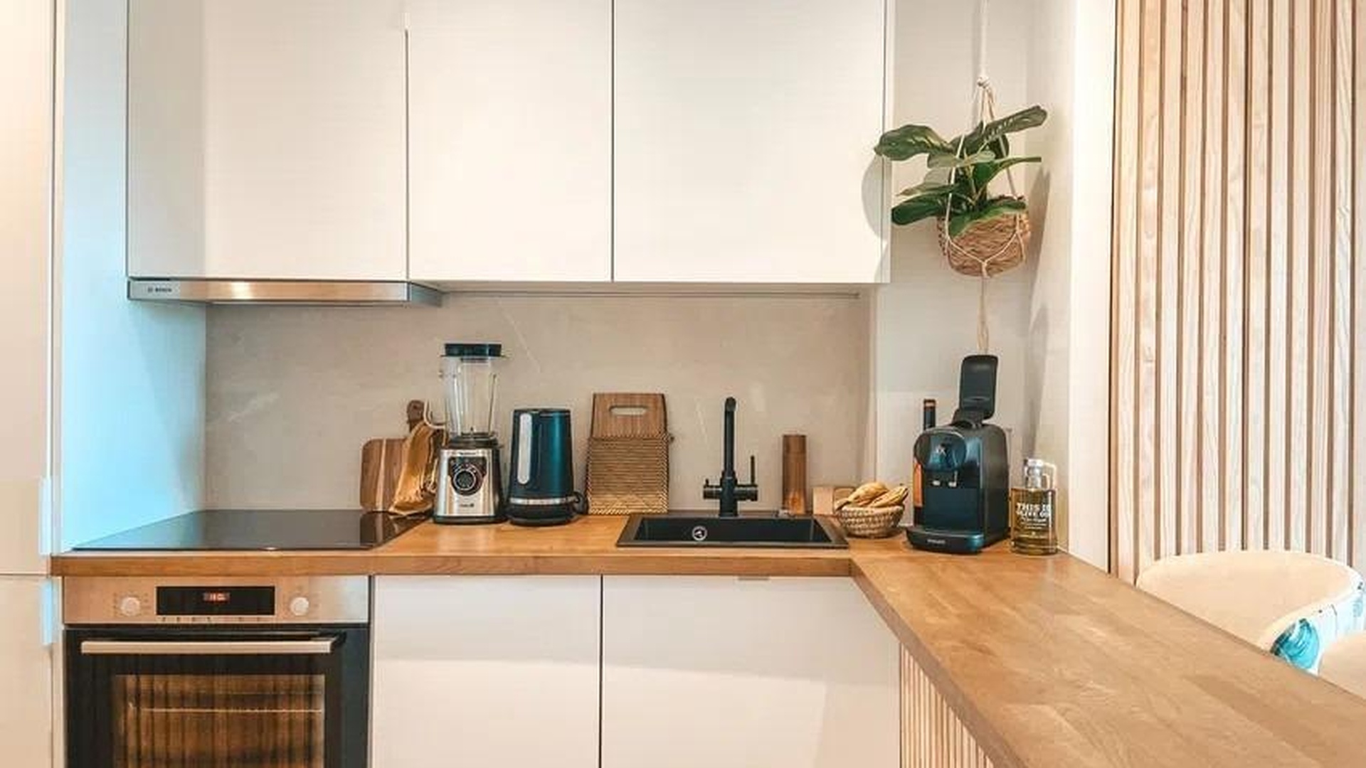 Aneks kuchenny z drewnianym blatem i jasnymi szafkami w apartamencie w Sant Agustí, Palma.