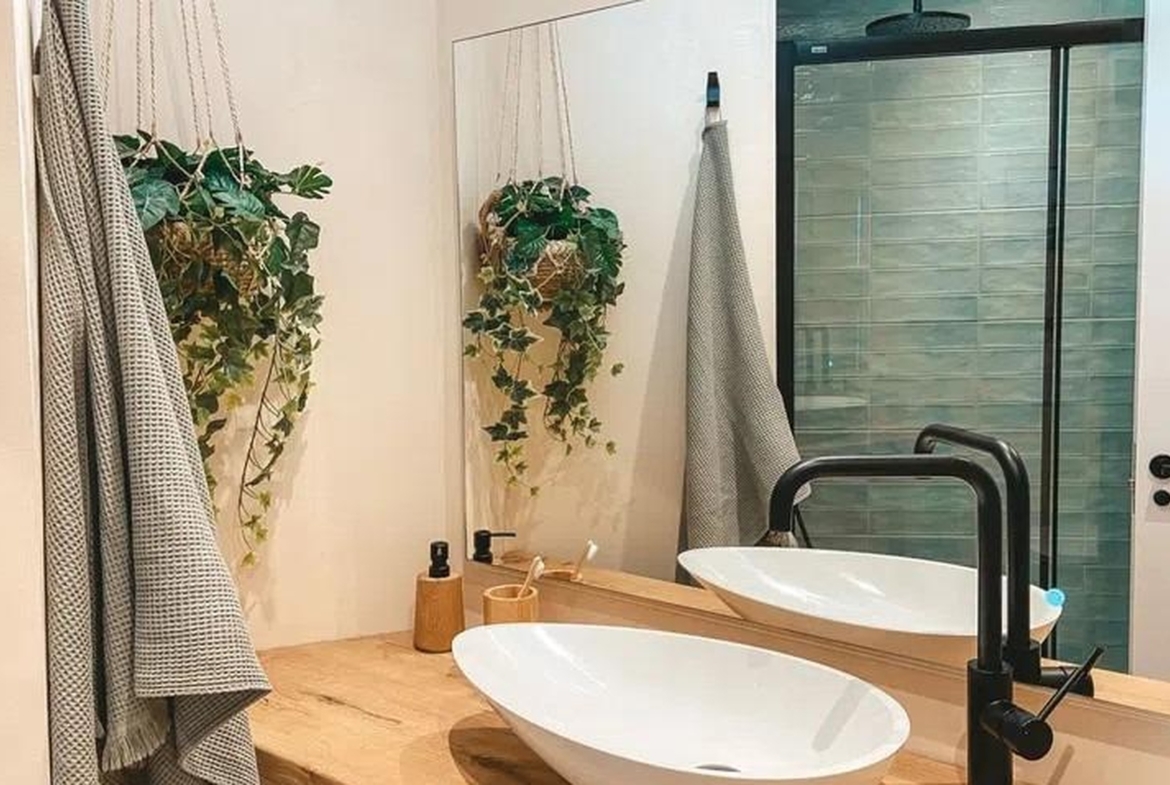 Nowoczesna łazienka z dużym lustrem, umywalką nablatową i wiszącymi roślinami – Sant Agustí, Palma de Mallorca.