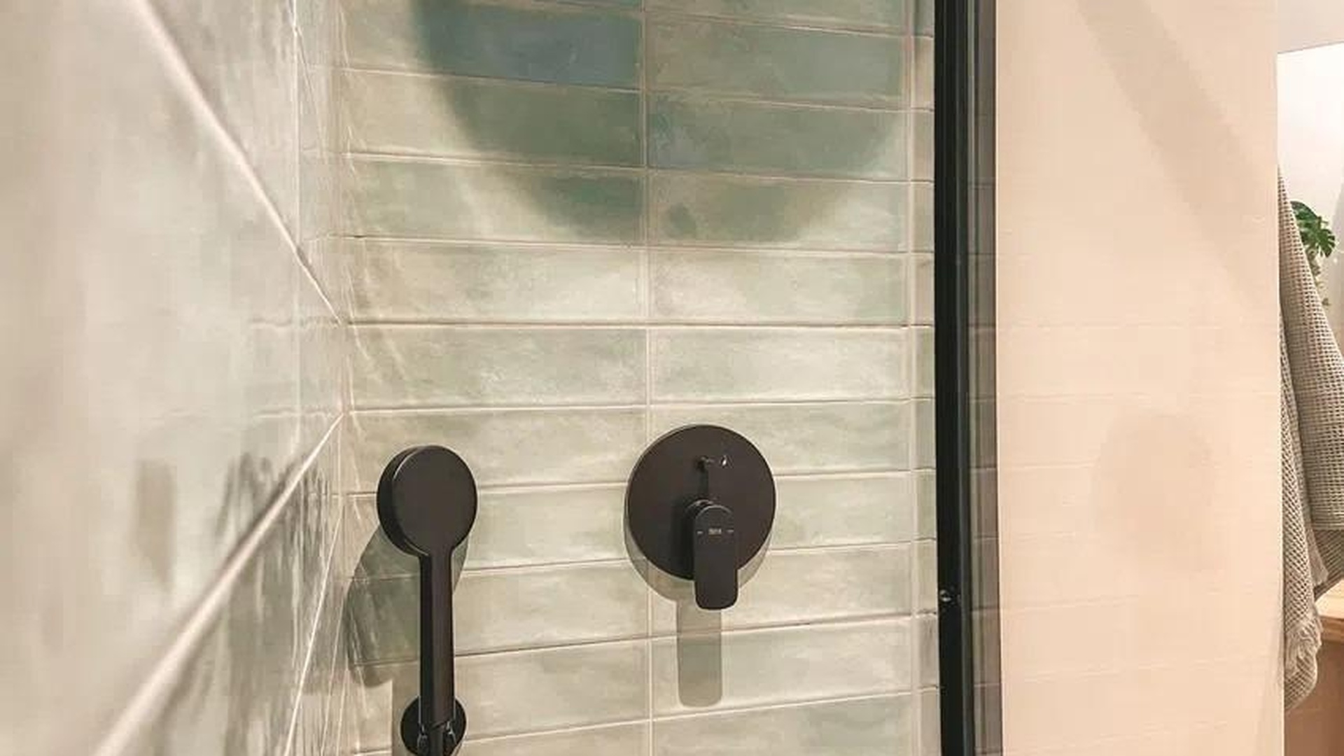 Strefa prysznica z zielonymi płytkami i czarną armaturą – apartament w Sant Agustí, Palma.