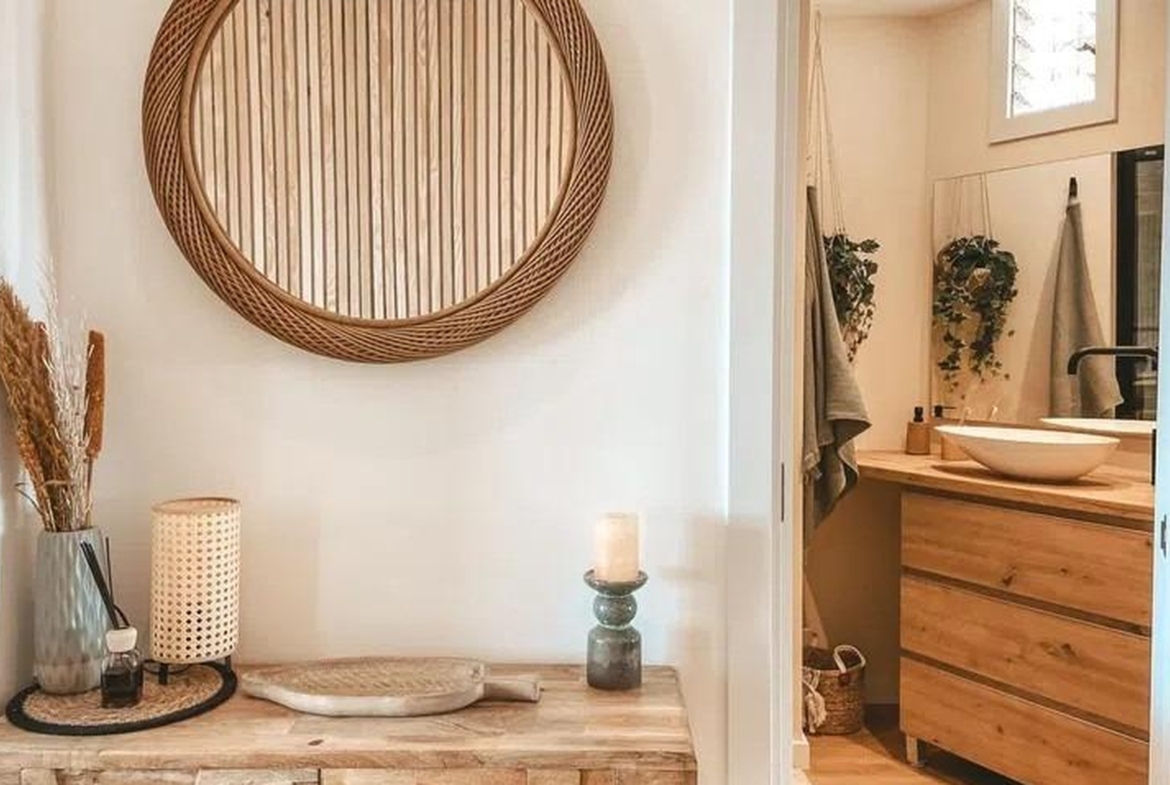 Przytulny przedpokój z okrągłym lustrem i drewnianą konsolą w apartamencie w Sant Agustí, Palma.