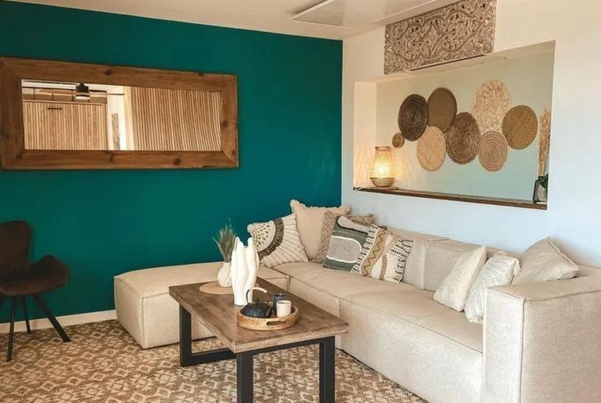 Jasny salon z dużym lustrem, sofa narożna i dekoracje w stylu boho w Sant Agustí, Palma de Mallorca.