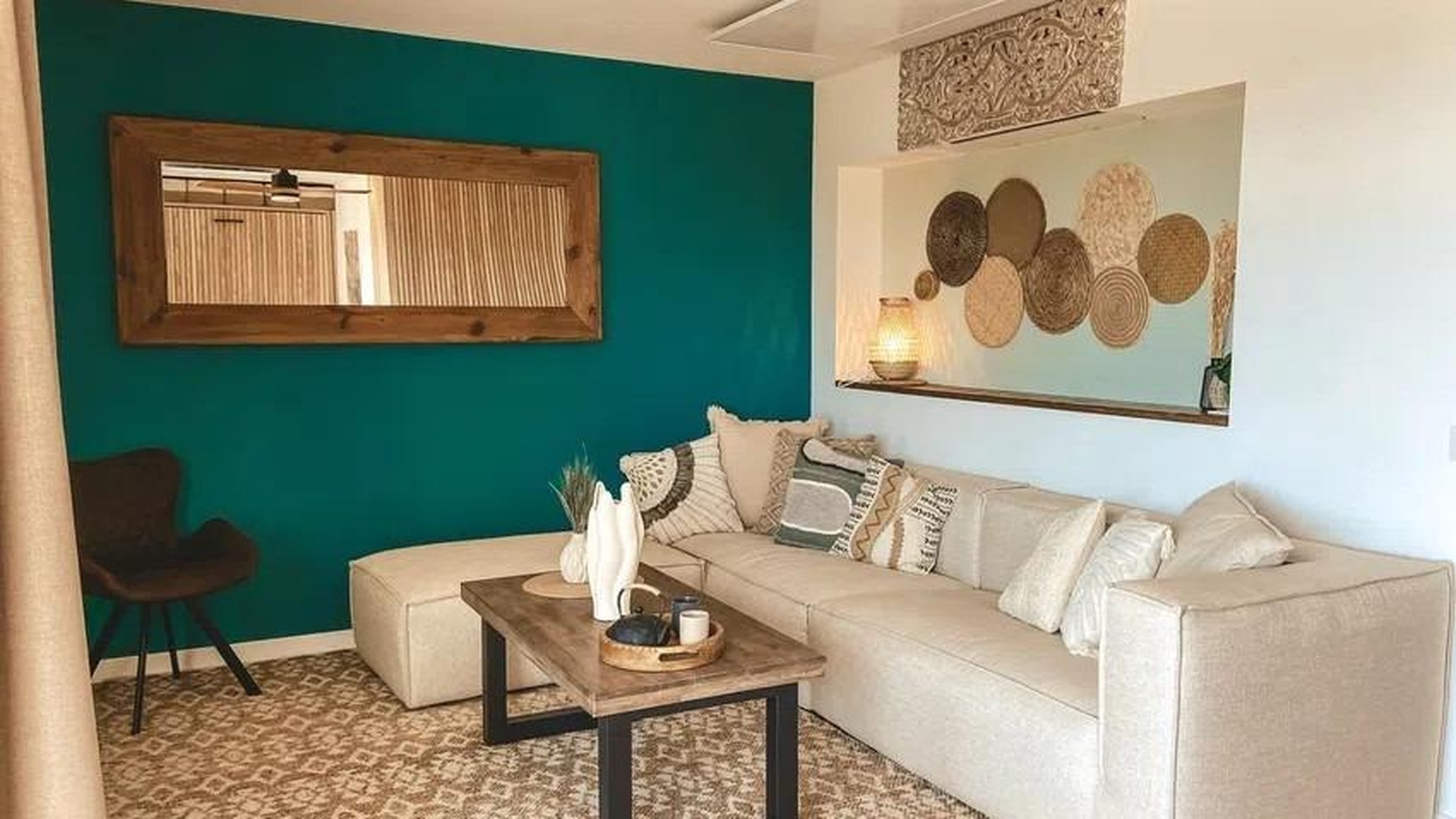 Jasny salon z dużym lustrem, sofa narożna i dekoracje w stylu boho w Sant Agustí, Palma de Mallorca.